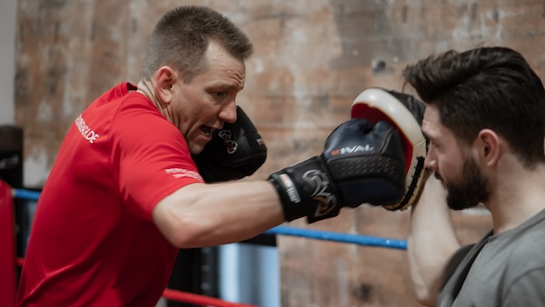 Ein männlicher Klient und Personal Boxtrainer Zeki Cizgec beim Sparring