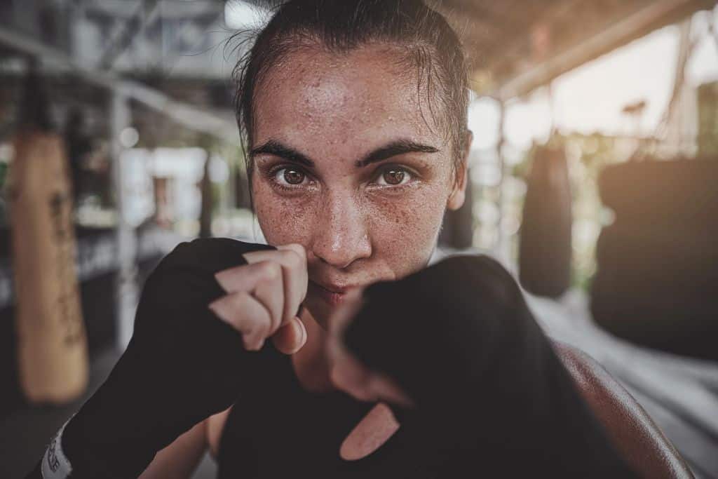 Boxer looks directly into the camera with raised fists, ready to fight